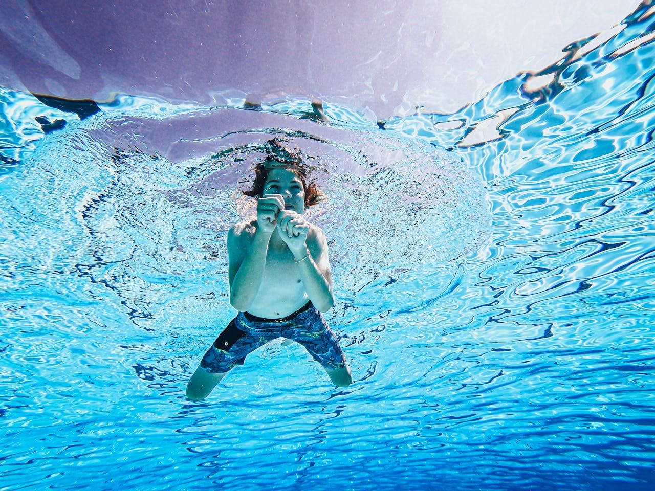 A boy swimming in clear pool water