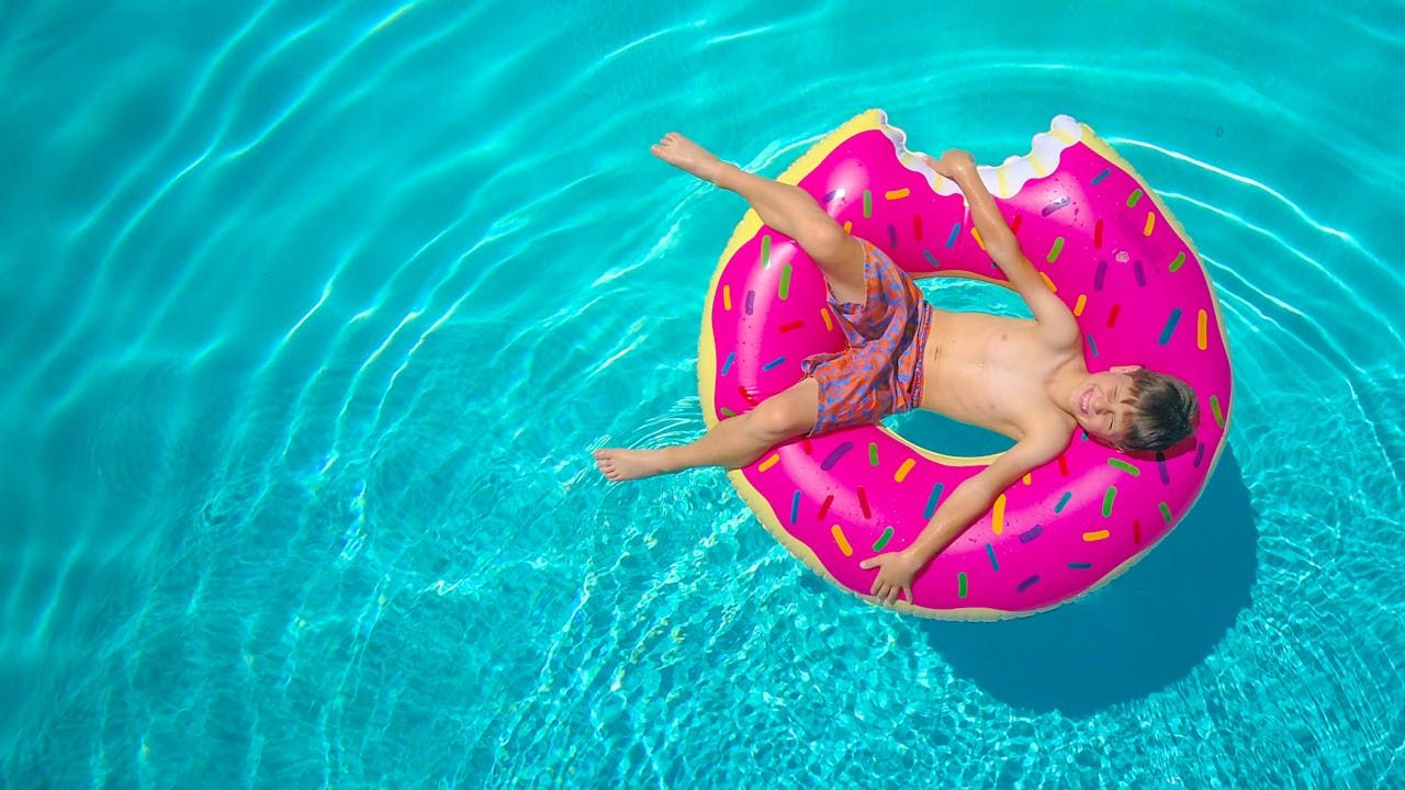 Child relaxing on an inflatable floater in the pool