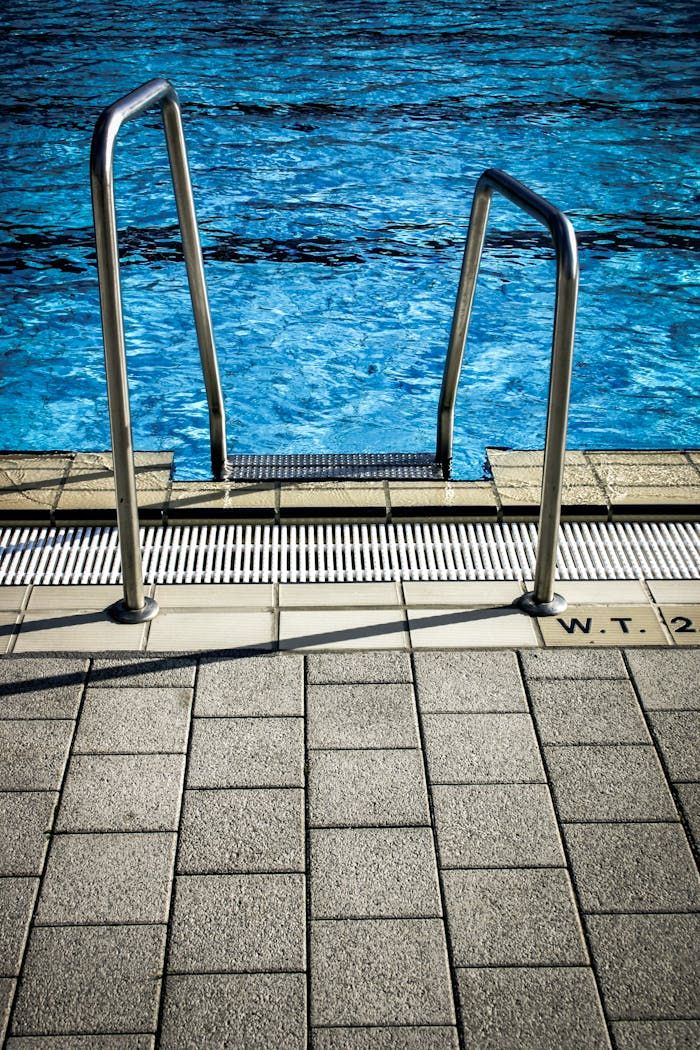 Steps and railing leading into a clean swimming pool